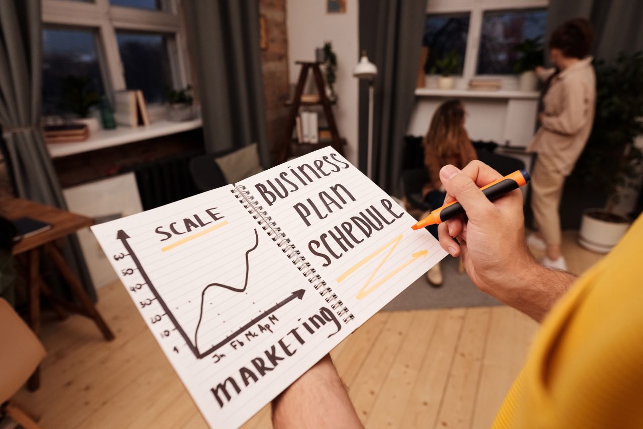 heros-img Person holding a notebook with planning details and graph for business strategy indoors.