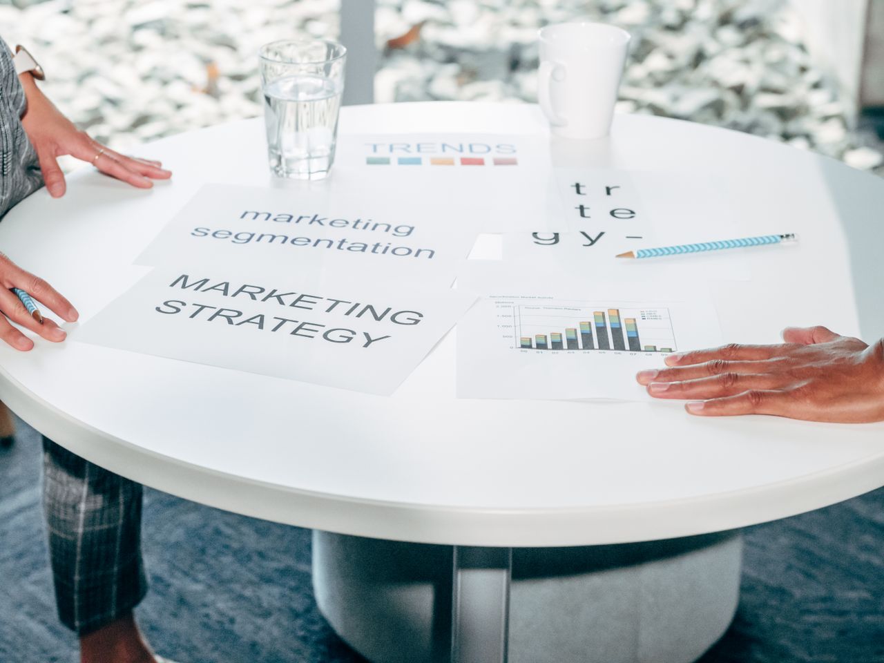 about-us Two professionals collaborate on marketing strategy and segmentation at a round table.